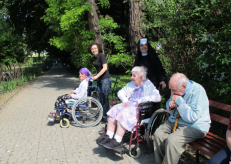 A Sister and a volunteer helping the residents take a walk